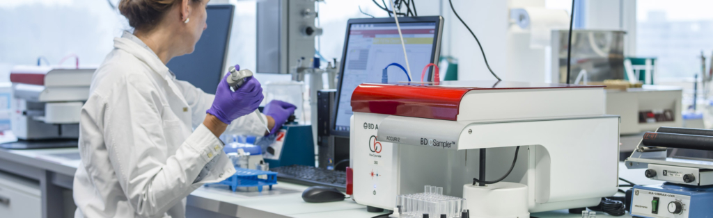 Une laborantine en blouse de laboratoire qui travaille sur une machine.